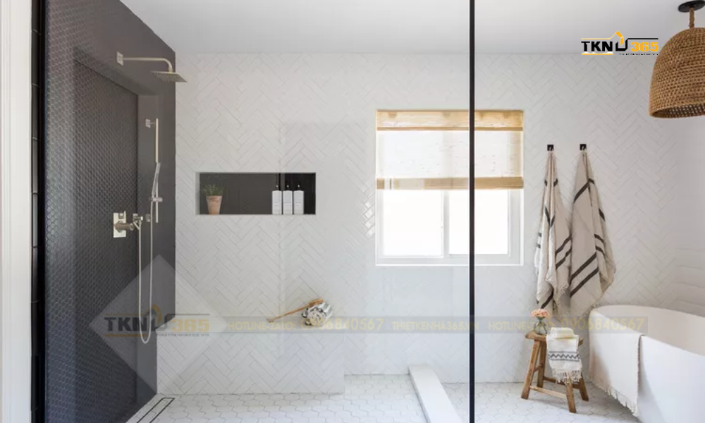 Không có quá nhiều đồ trang trí, chỉ có những chiếc đèn trần với chụp đèn gỗ, không gian phòng tắm hiện lên vẻ đơn giản và thanh lịch