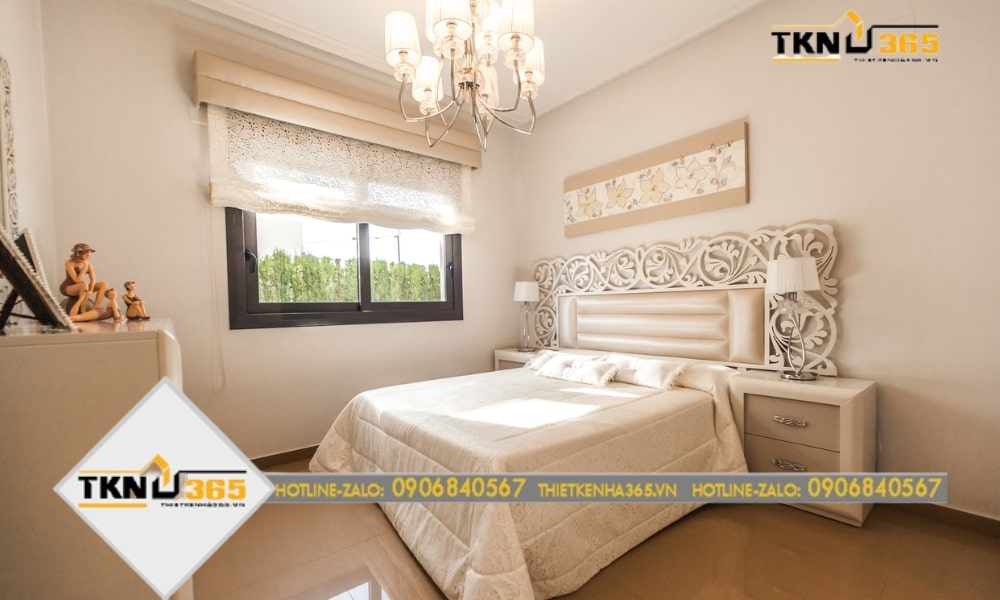 Phòng ngủ có không gian lãng mạn với đèn trang trí nghệ thuật, hoa văn nhẹ nhàng ở đầu giường, rèm cửa