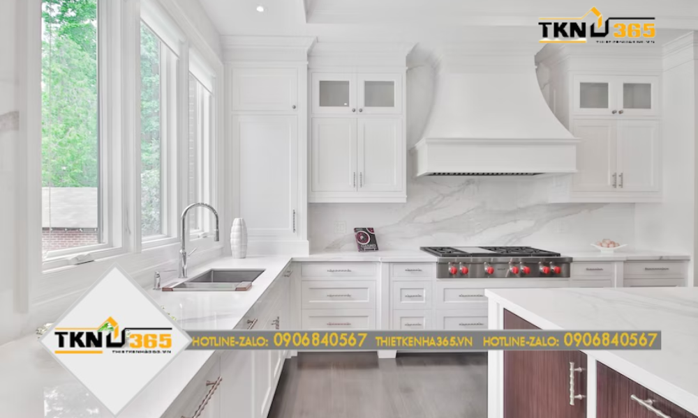 Nhà bếp dùng màu trắng tinh khiết làm chủ đạo, chỉ nhấn nhá ở vài chi tiết thiên về tone đỏ như bếp nấu, cửa tủ