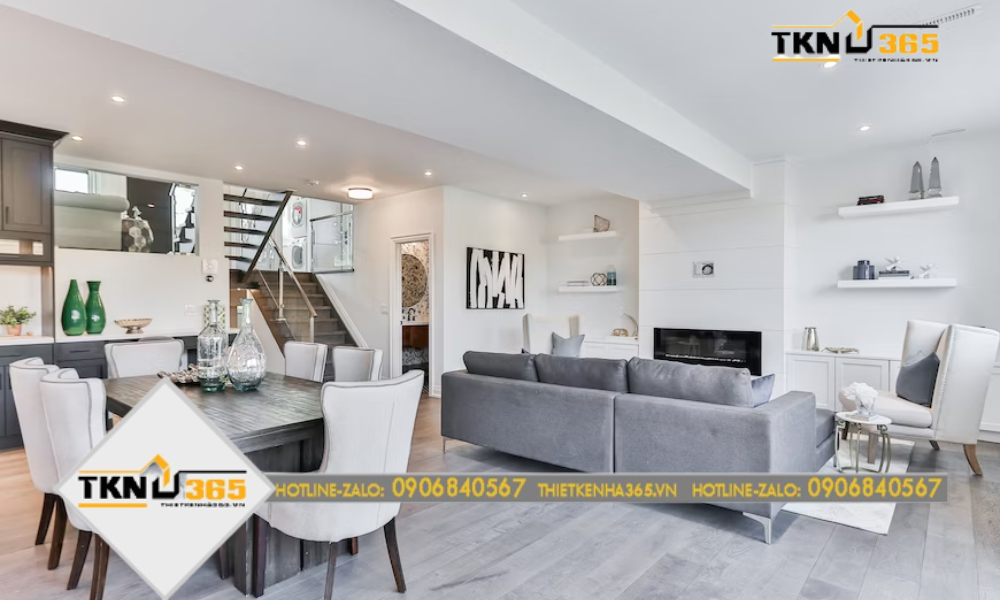 Phòng khách hiện đại trong gam trắng chủ đạo, kết hợp với sofa xám và bộ bàn ăn sang trọng