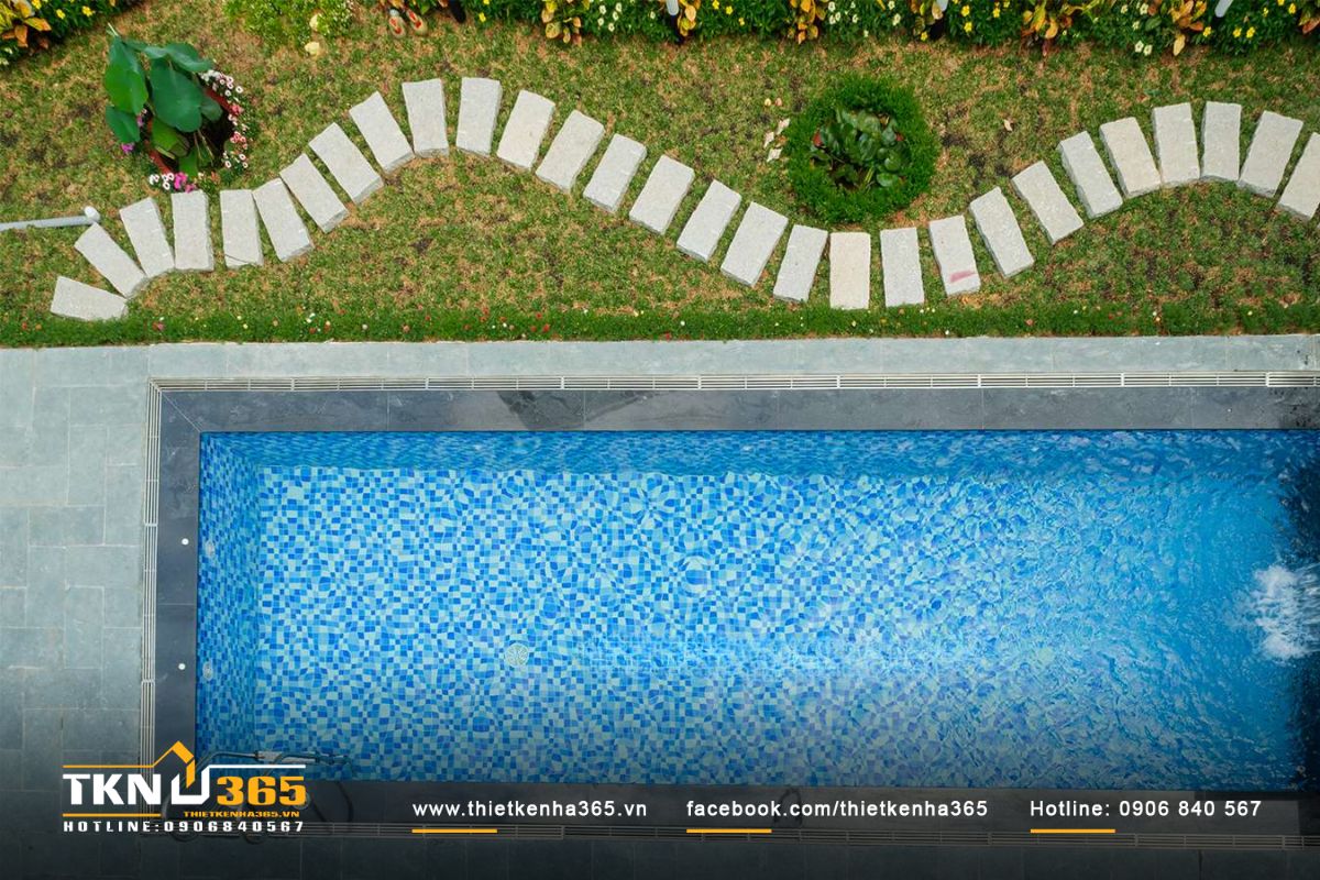 Bể bơi hình chữ nhật hiện đại nằm bên hông biệt thự là không gian thư giãn ngoài trời lý tưởng để gia đình nằm ngâm mình trong làn nước xanh