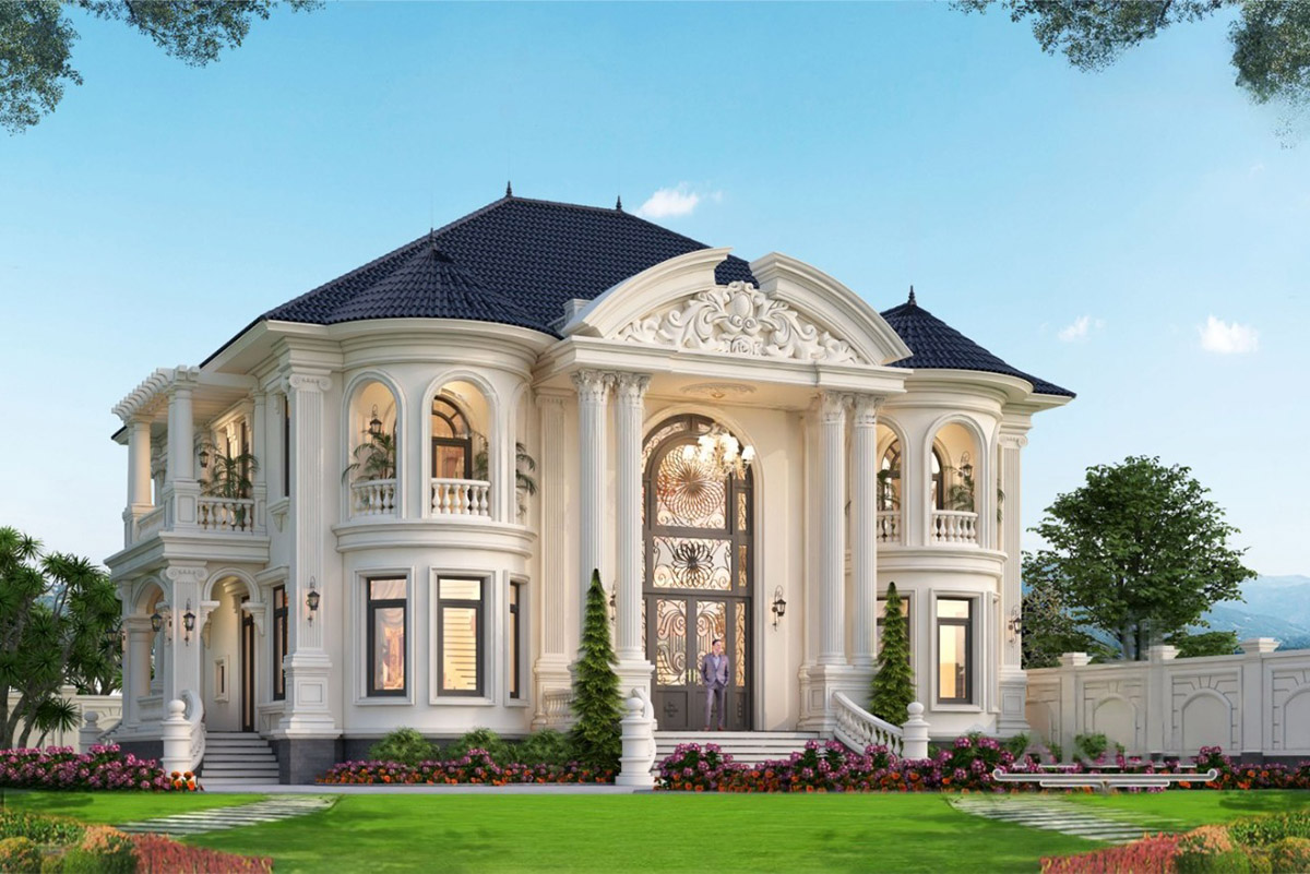 Toàn bộ mặt tiền sơn trắng trang nhã, điểm xuyết ban công bán nguyệt, lan can hoa nhôm đúc mạ vàng và cửa kính khung nhôm cao cấp giúp không gian luôn thoáng sáng.