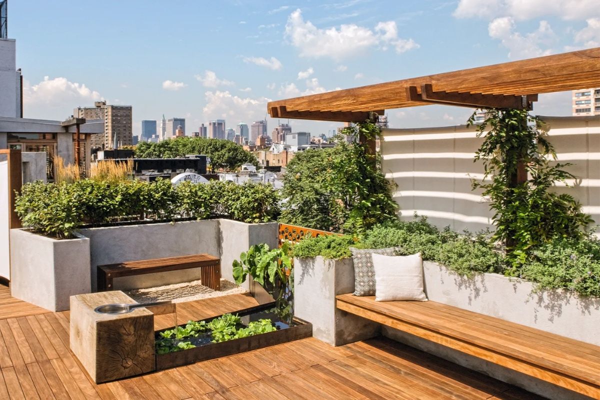 Vườn trên sân thượng với chất liệu gỗ là chủ đạo, kết hợp cây bụi, dây leo và hồ nước, mang đến không gian thư giãn nhẹ nhàng (Ảnh: Sưu tầm)