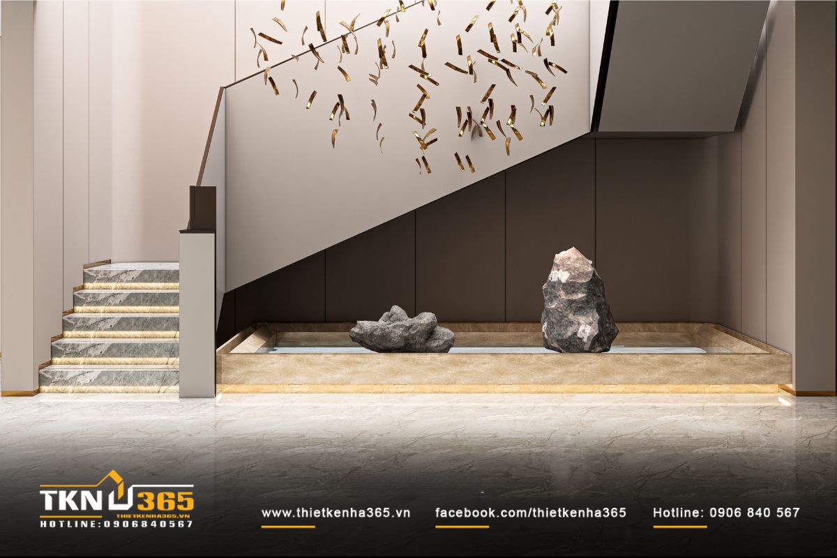 Bể cạn đặt đá tự nhiên và đèn hắt âm sàn tạo điểm nhấn cho khu vực cầu thang của biệt thự 3 tầng