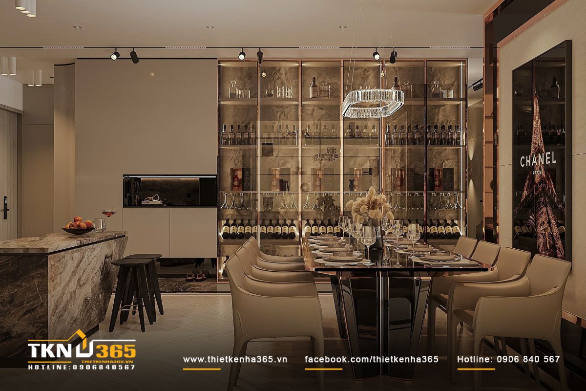 Bàn ăn lớn đặt song song khu bếp, điểm nhấn bằng kệ trưng rượu âm tường và đèn pha lê hiện đại, khơi gợi cảm giác sum họp ấm cúng
