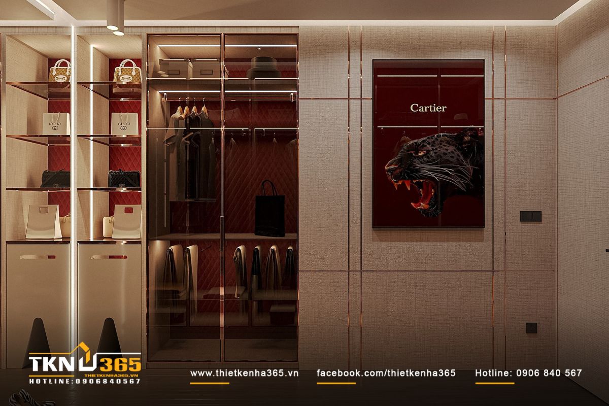 Sắc đỏ trầm kết hợp ánh sáng vàng tạo chiều sâu thị giác cho không gian thay đồ, tranh Cartier nổi bật như điểm nhấn phong cách