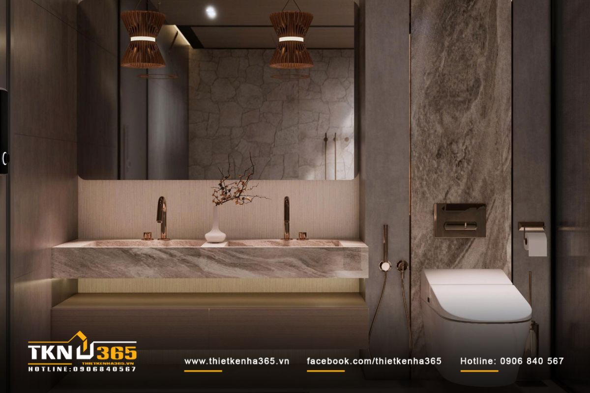 Lavabo đôi bằng đá tự nhiên kết hợp vòi đồng ánh vàng, phản chiếu nhẹ dưới ánh sáng từ giếng trời