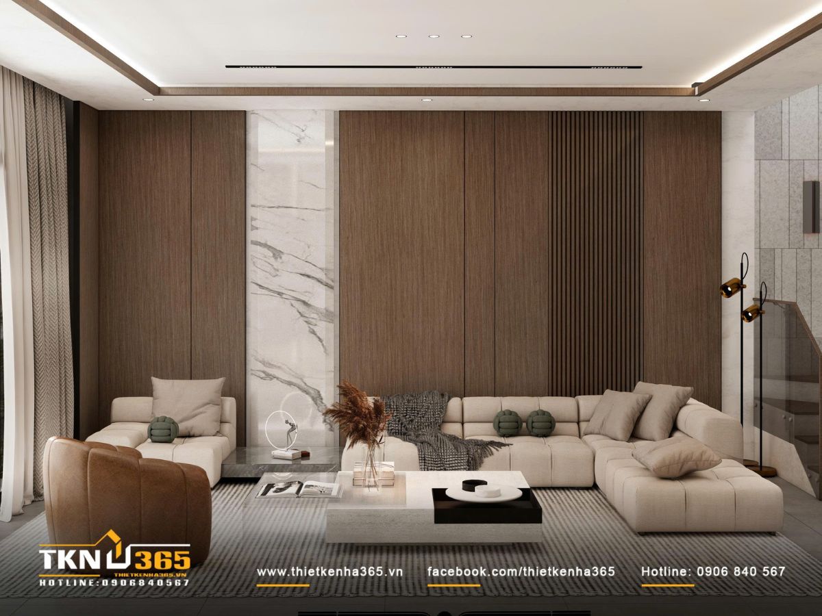Phòng khách gây ấn tượng với mảng tường ốp gỗ - đá và sofa chữ L màu kem, mang lại cảm giác ấm áp và hiện đại