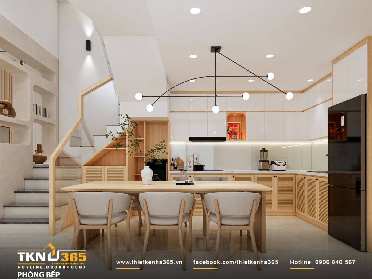 Hệ tủ bếp chữ L màu trắng phối gỗ và cánh nan thông thoáng, mặt bếp đá sáng cùng kính ốp trắng sữa giúp không gian luôn sạch và sáng