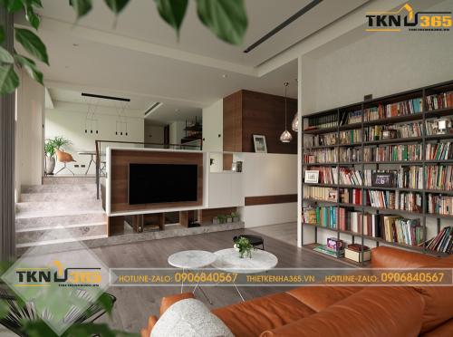 Phòng khách với một bộ ghế salon màu da bò, có thêm giá sách và kệ tivi bằng gỗ công nghiệp